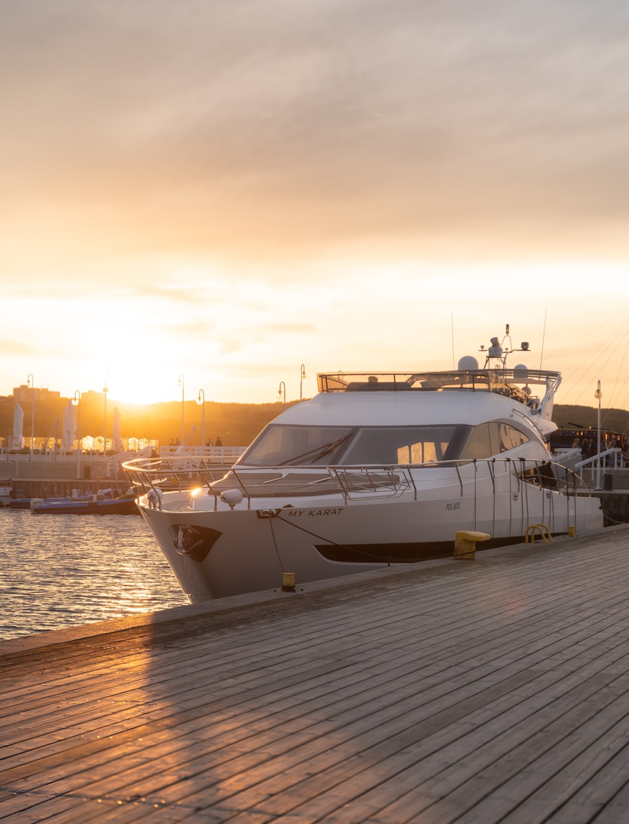 white and black yacht on dock during sunset